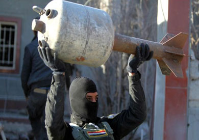 احد جنود الجيش العراقي في جبهة الرمادي وهو يحمل قذيفة صنعت محليا من قنينة للغاز
